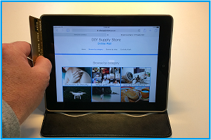Online Mall picture os a iPad with a mans hand swiping a credit card as if to make a purchase. An inage link to the information page section "Why buy online".